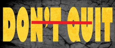 Chữ 'DON'T QUIT' màu vàng với gạch đỏ ngang qua chữ 'QUIT', nền xám giả đá nứt